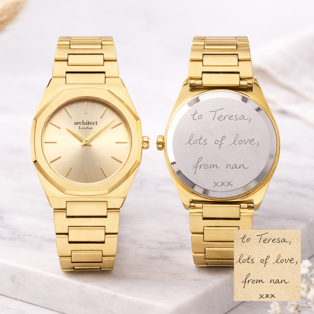 Two gold watches on a marble surface with a handwritten note.