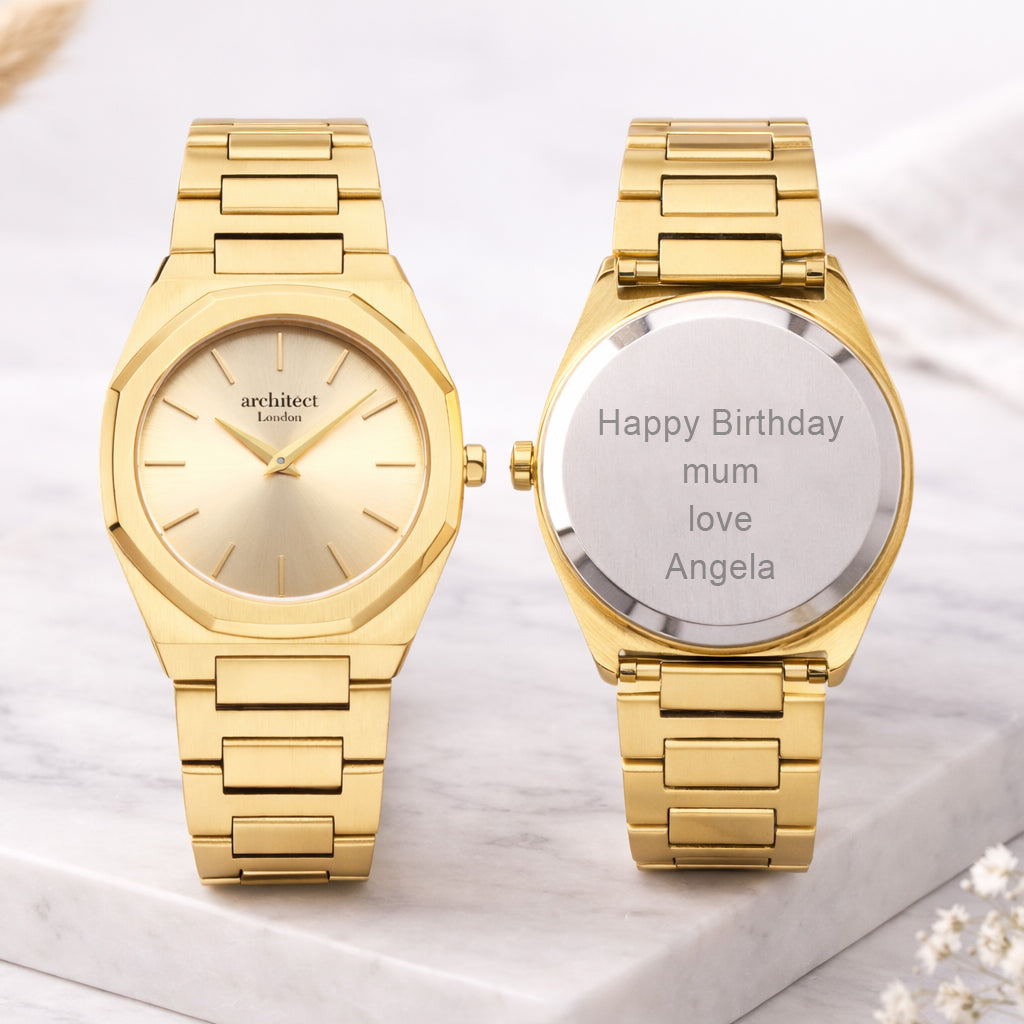 Two gold watches on a marble surface, one with a brand name and the other with a personalised message.