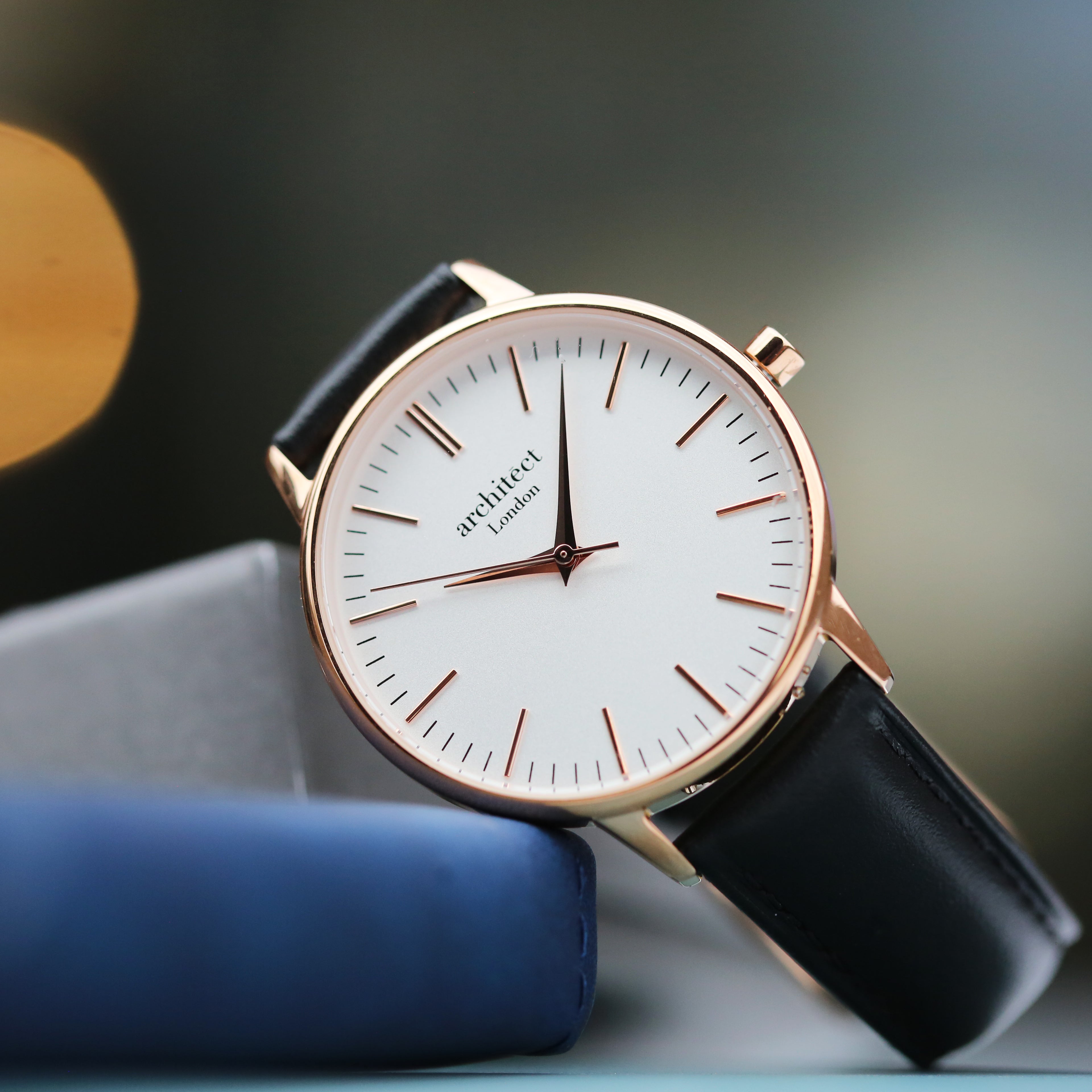 Rose gold ladies watch with black leather strap in elegant minimalist setting